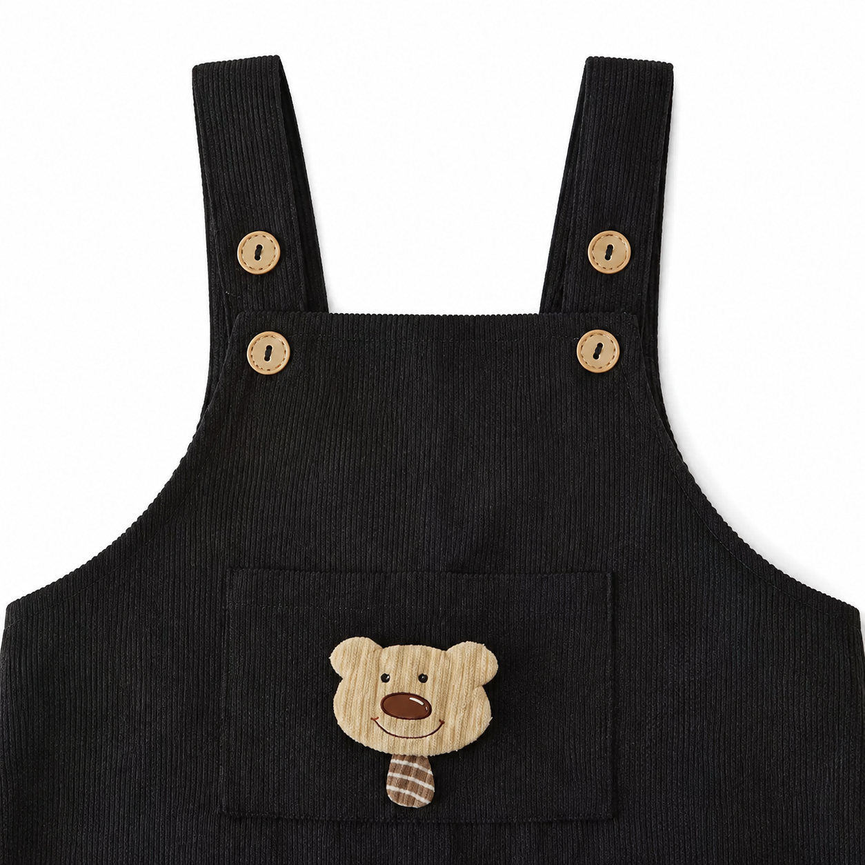 Close-up of the shoulder strap and button detail on the black overalls.