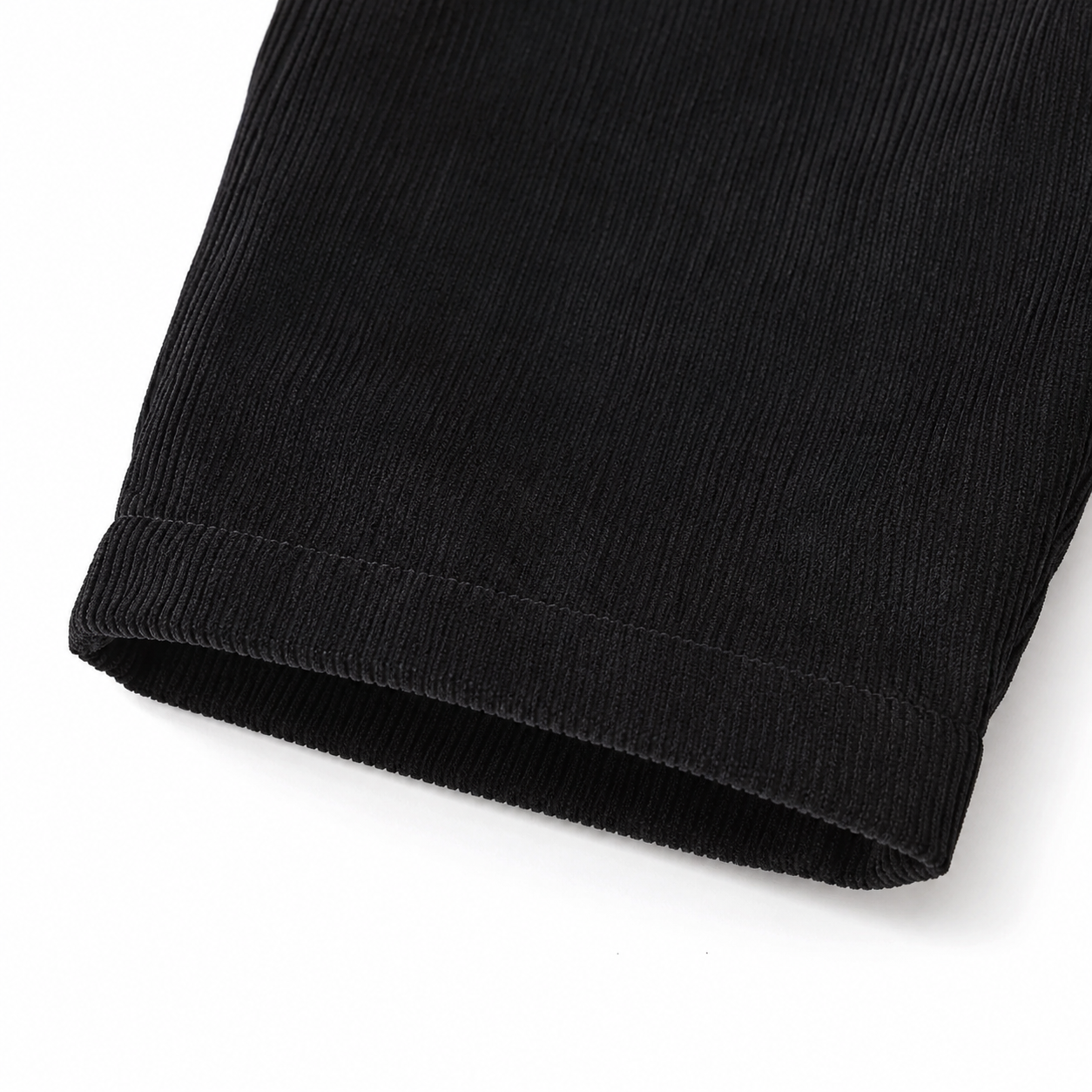 Close-up of the corduroy texture and pant leg hem on the black overalls.