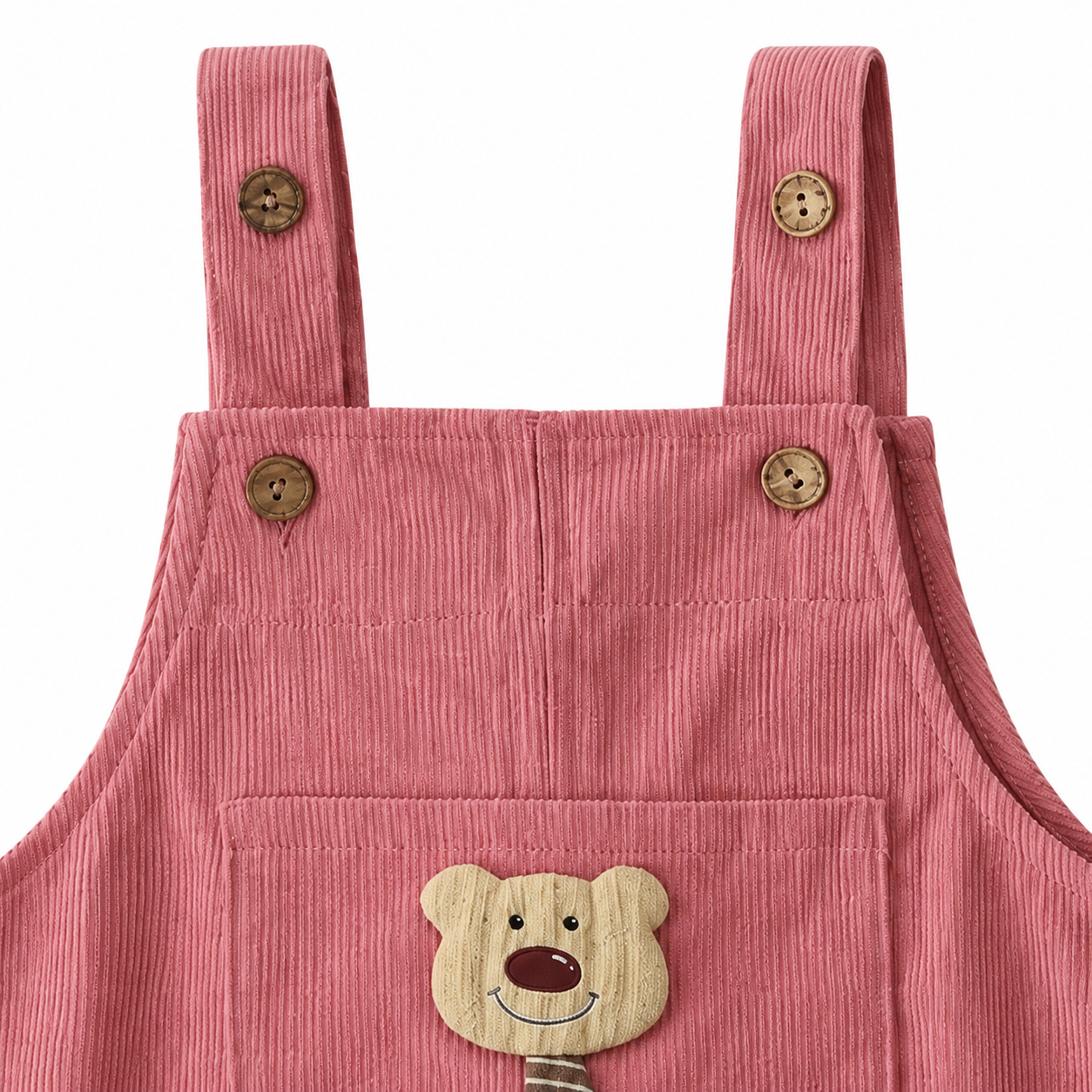 Close-up of the shoulder strap and button detail on the dusty rose overalls.