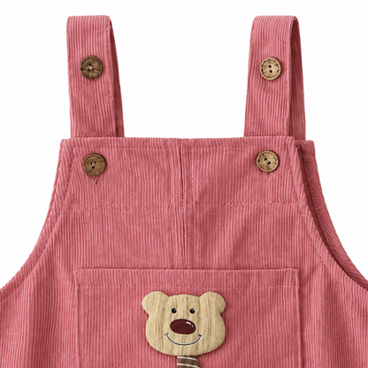 Close-up of the shoulder strap and button detail on the dusty rose overalls.