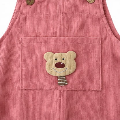 Close-up of the bear applique pocket on the dusty rose corduroy overalls.