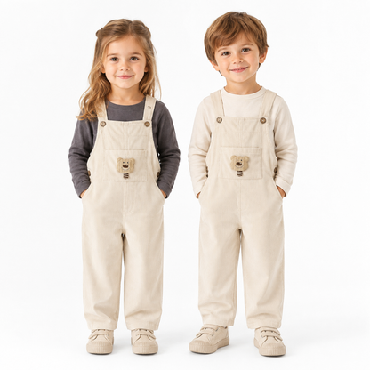 Girl and boy child models wearing the ivory kids corduroy bib overalls.