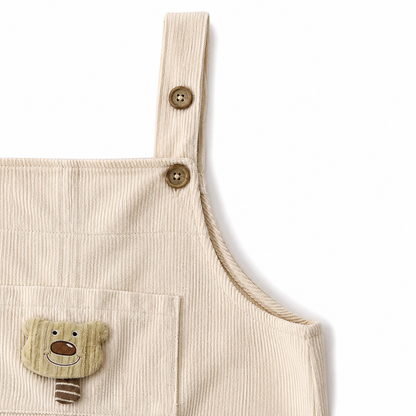 Close-up of the upper bib and side seam detail on the ivory overalls.