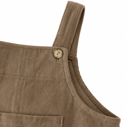 Close-up of the upper bib and side seam detail on the taupe overalls.