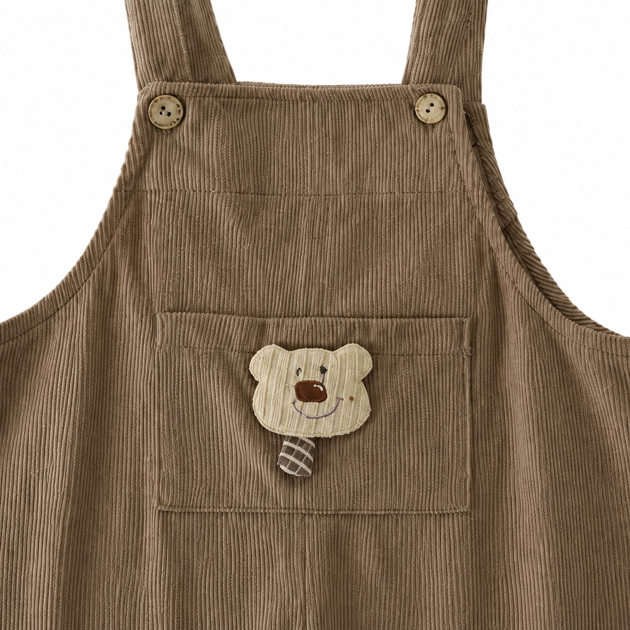 Close-up of the bear applique pocket on the taupe corduroy overalls.