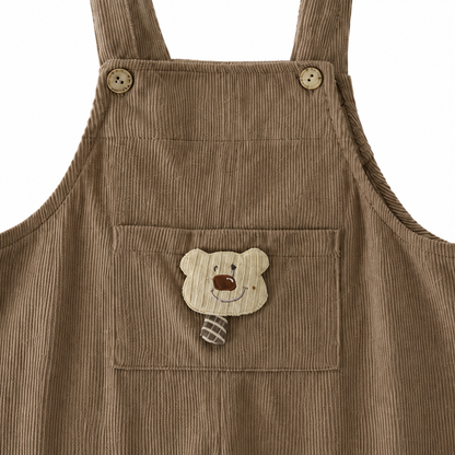 Close-up of the bear applique pocket on the taupe corduroy overalls.