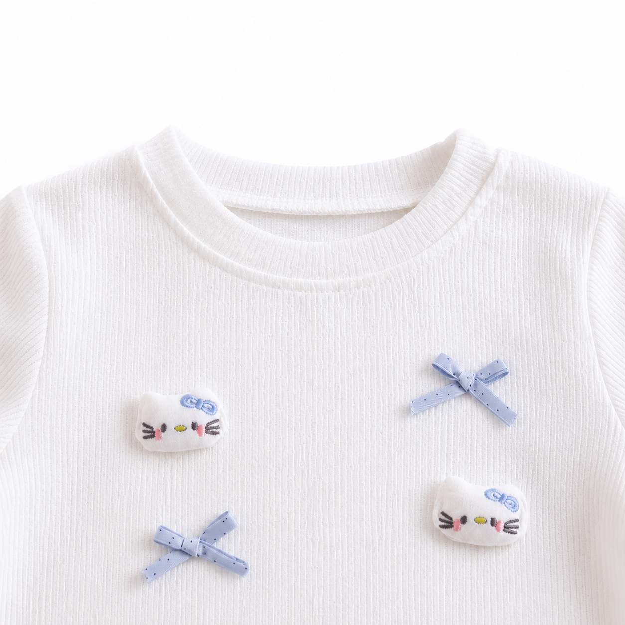 Close-up of the round neckline detail on a white girls cotton top.