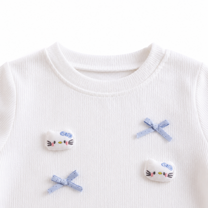 Close-up of the round neckline detail on a white girls cotton top.