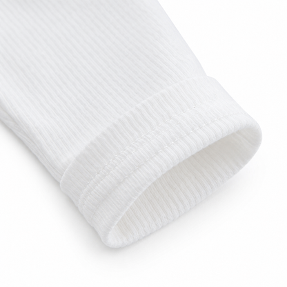 Close-up of the sleeve cuff detail on a white girls long sleeve cotton top.
