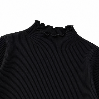 Close-up of the black ruffle-edge neckline and vertical ribbed texture.