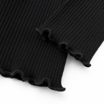 Close-up of the black lettuce-edge hem and ribbed knit detail.