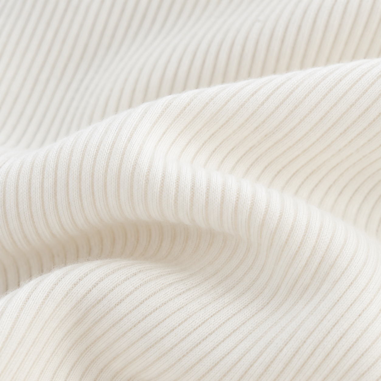 Close-up of the ivory ribbed fabric texture and finished edge.