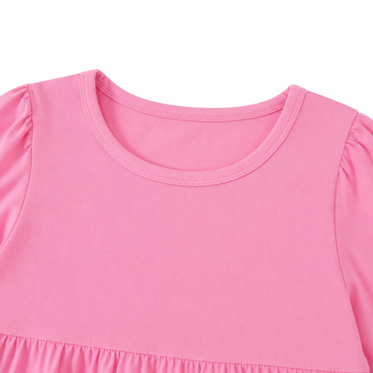 Close-up of the round neckline and gathered shoulder detail on the pink girls dress.