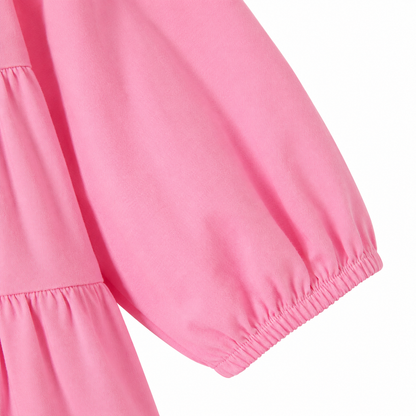 Close-up of the long sleeve and elastic cuff on the pink cotton dress.
