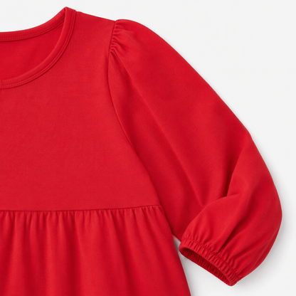 Close-up of the long sleeve and elastic cuff on the red cotton dress.