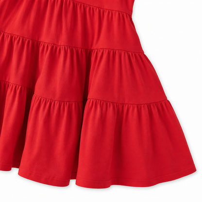 Close-up of the gathered tiered skirt and hem detail on the red girls dress.
