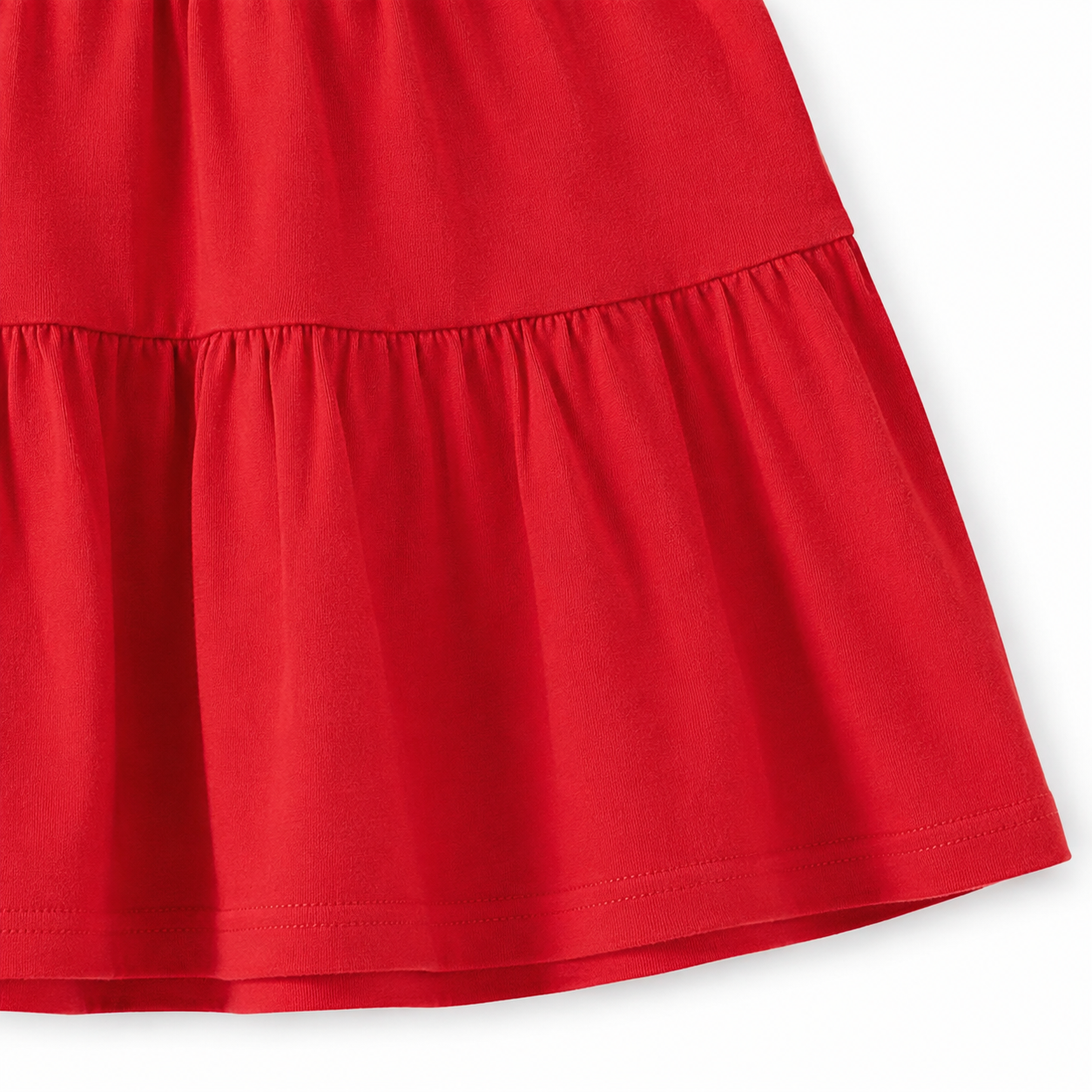 Close-up of the elastic cuff and cotton fabric texture on the red long sleeve dress.