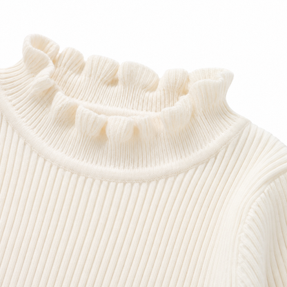 Close-up of the ruffle mock neck detail on the ivory girls long sleeve top.