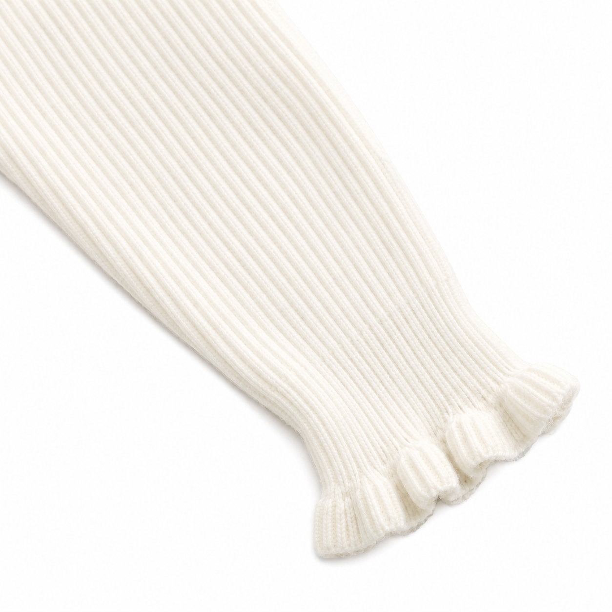 Close-up of the ruffle cuff sleeve detail on the ivory ribbed long sleeve top.