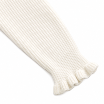 Close-up of the ruffle cuff sleeve detail on the ivory ribbed long sleeve top.