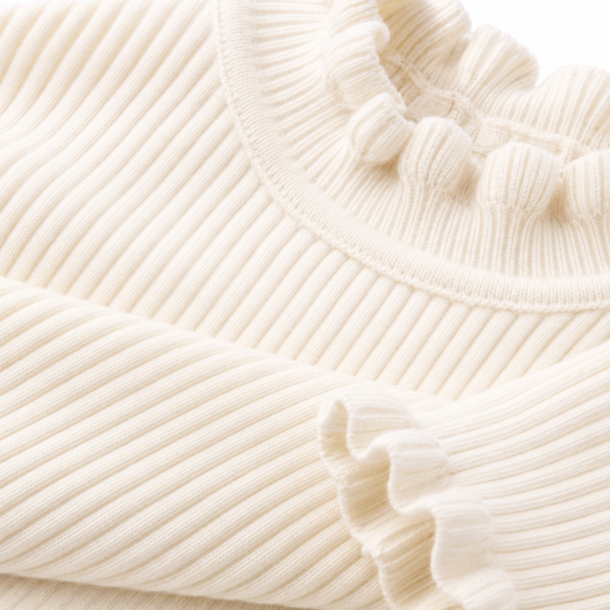 Close-up of the ribbed fabric texture on the ivory long sleeve girls top.