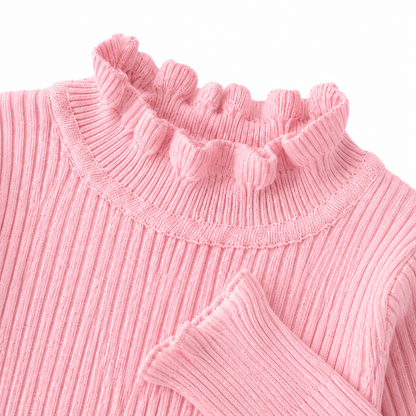 Close-up of the ruffle hem and ribbed texture on the pink girls top.