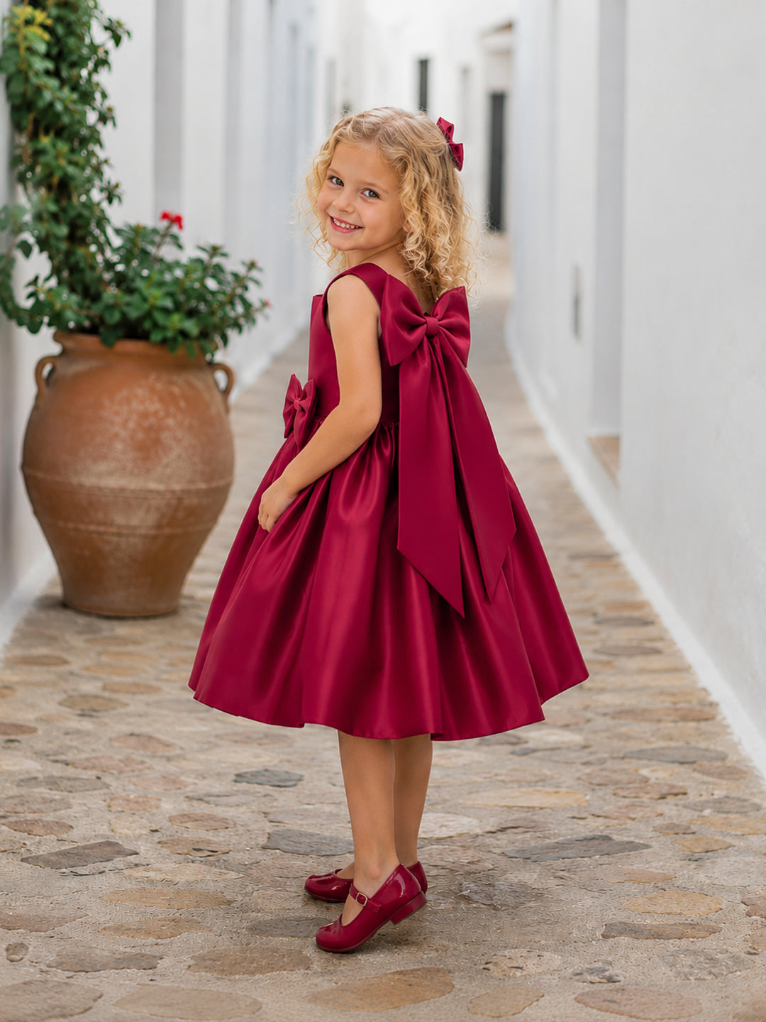 Girl wearing the Estelle Bow Dress with a large back bow